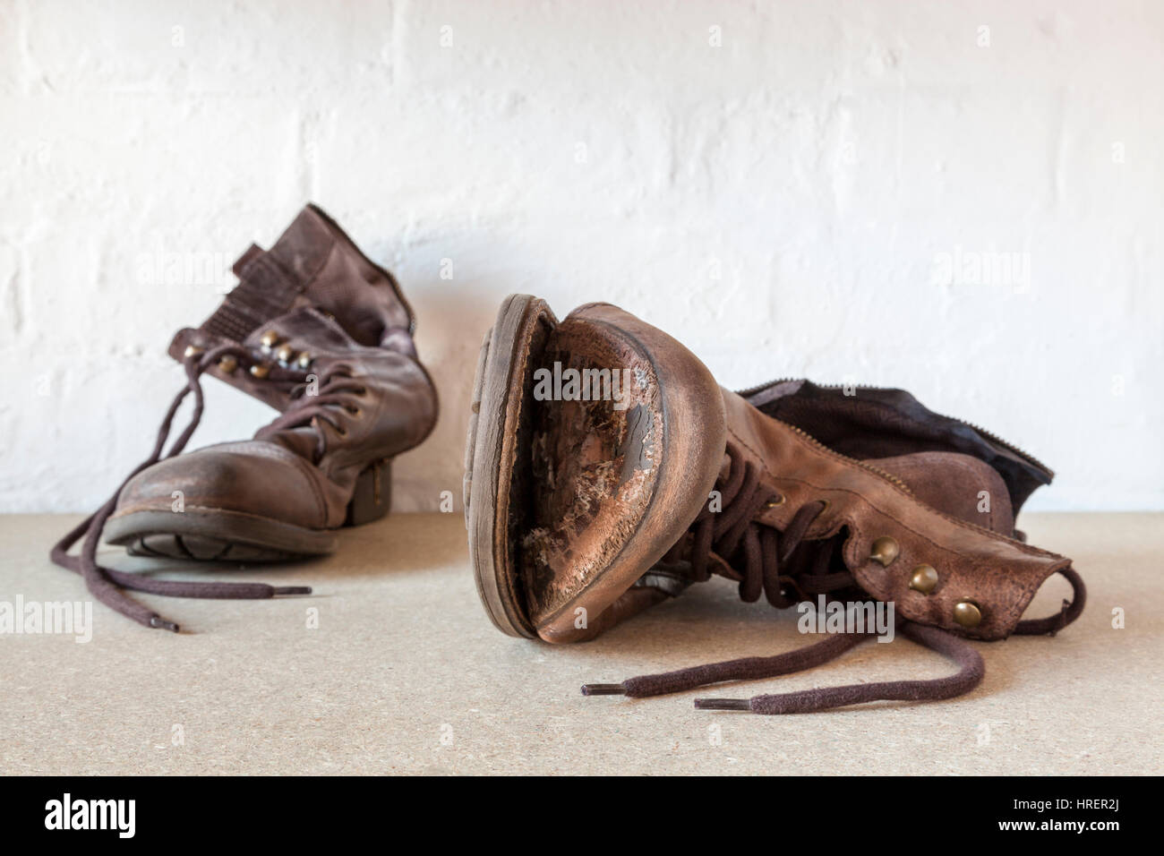 Viejas botas desgastadas, una bota con la suela que sale y más allá de la reparación Foto de stock
