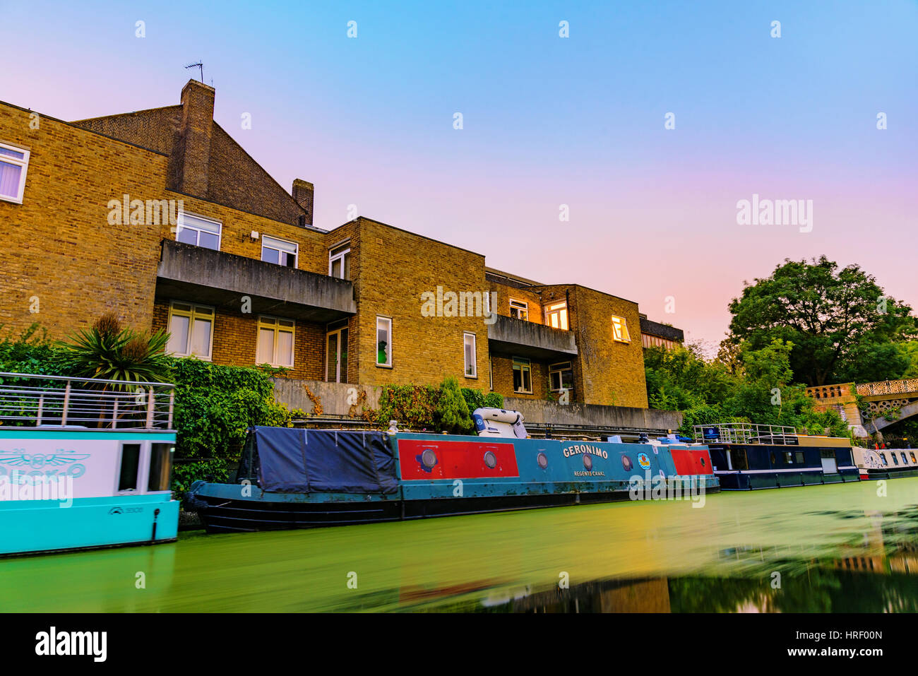 Londres - 16 de julio de 2016: Riverside Apartments con barco casas de noche a lo largo del Parque Regents Canal, que es una famosa vía fluvial en julio de 2016 en Londres. Foto de stock