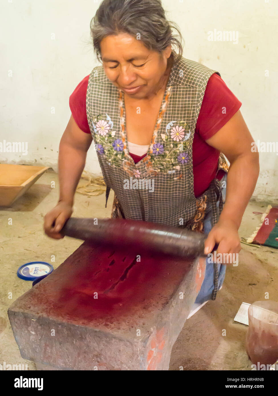 Mujer zapoteca moliendo insectos a hacer valiosas del tinte de la cochinilla, Teotitlan del Valle, Oaxaca, México, América del Norte Foto de stock