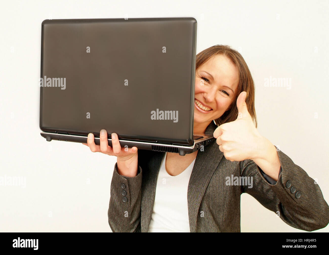 Junge, Gesch optimistische?ftsfrau mit Laptop - joven y exitosa mujer de negocios con ordenador portátil, Symbolfotos Foto de stock