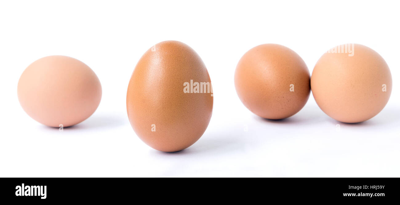 Brown vertical y tres detrás de huevo de gallina aislado en blanco. Foto de stock