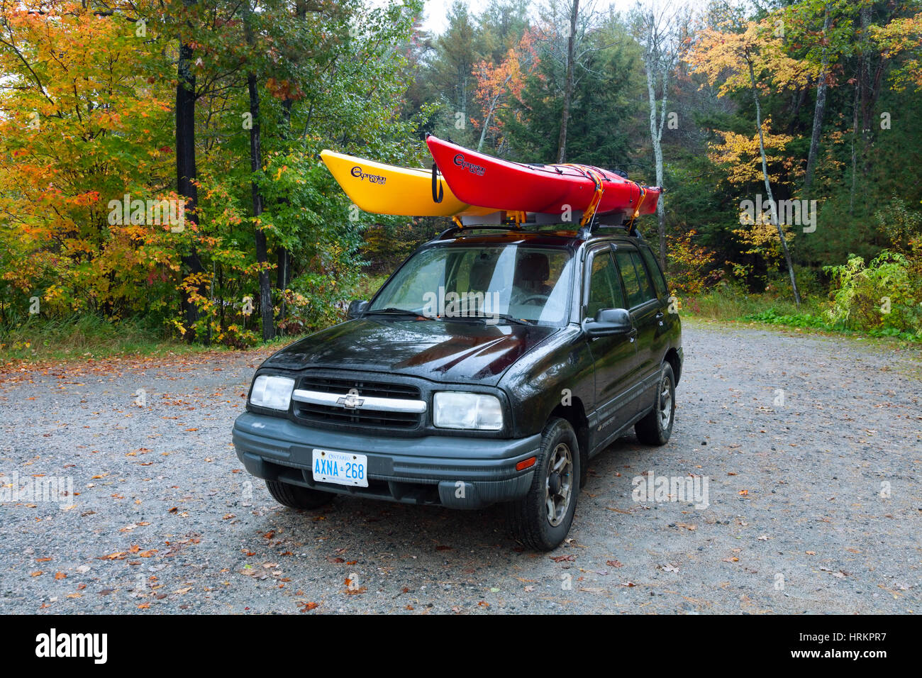 Dos kayaks montada en el techo de un SUV (Chevrolet Tracker) en otoño Dos kayaks montada en el techo de un SUV (Chevrolet Tracker) en otoño