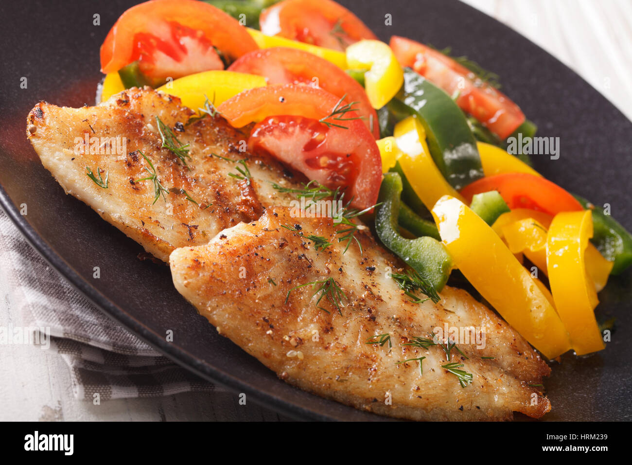Filetes de tilapia a la parrilla y ensalada de verduras frescas en una  placa horizontal cerca Fotografía de stock - Alamy