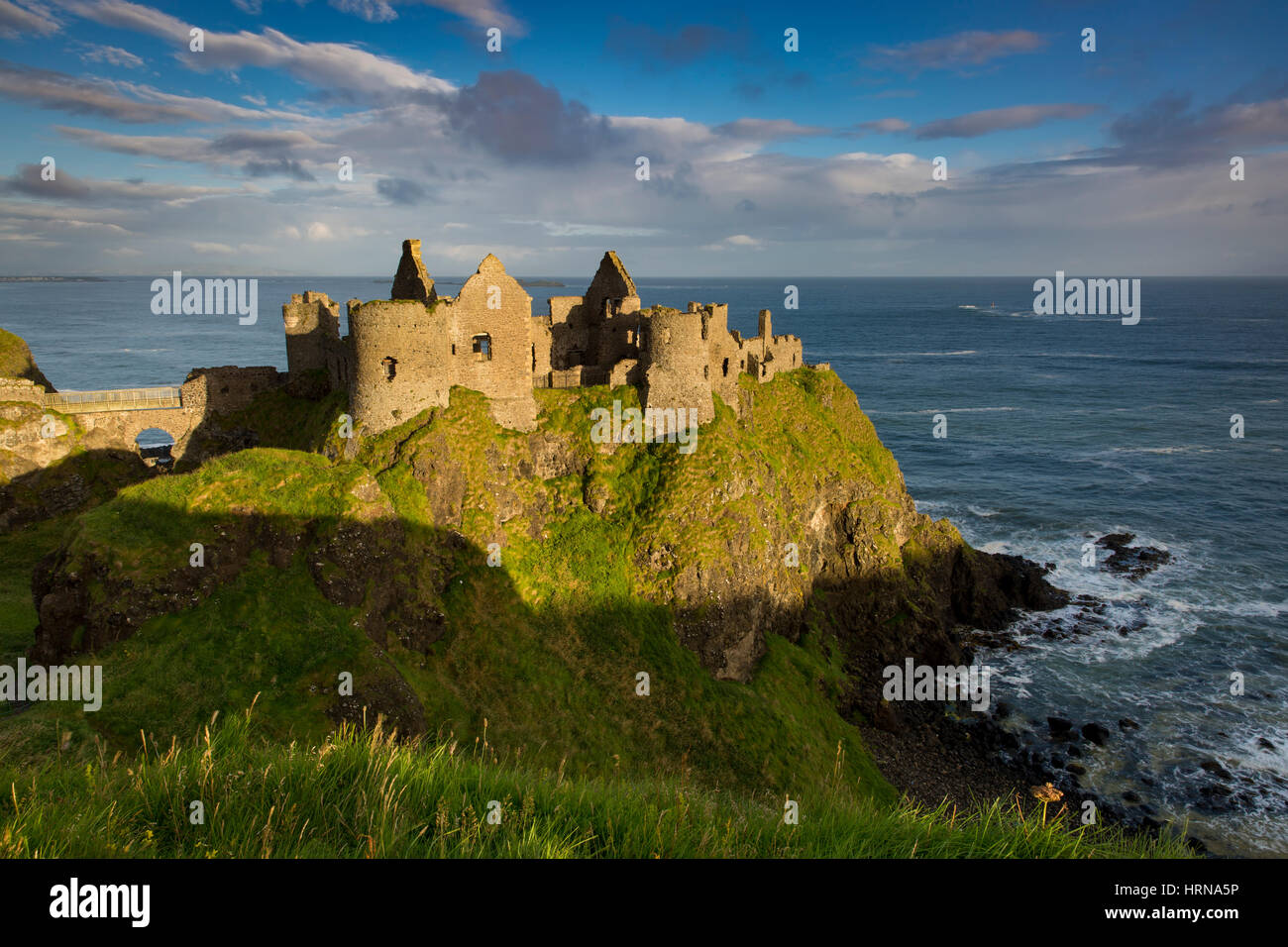 Amanecer sobre Castillo de Dunluce a lo largo de la costa norte del Condado de Antrim, Irlanda del Norte, REINO UNIDO Foto de stock