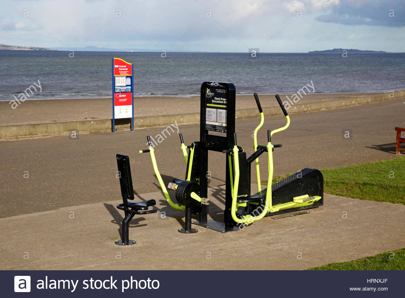 Presione el pecho y una bicicleta estacionaria de ejercicio al aire libre en equipos Cramond Promenade, Edimburgo Foto de stock