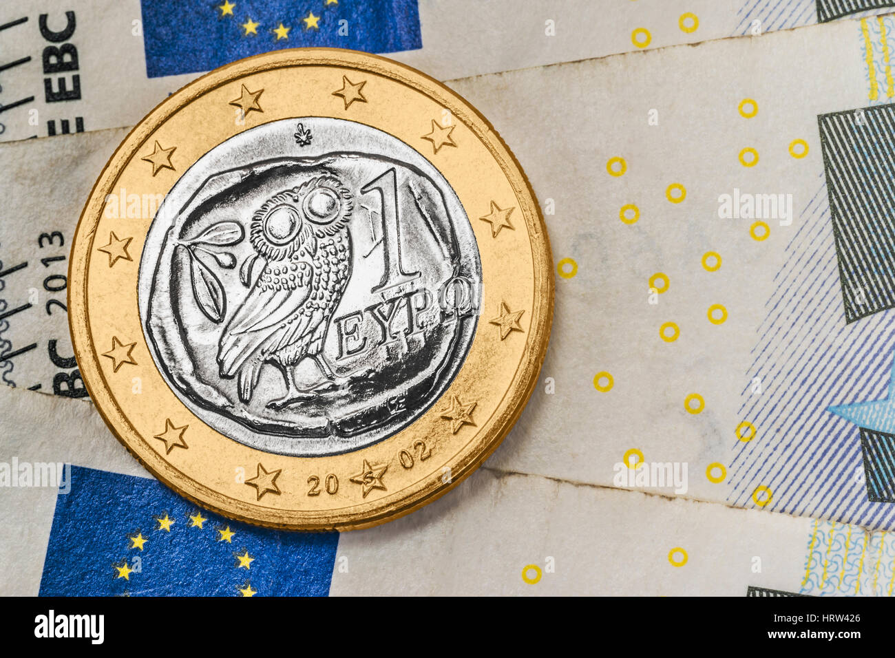 Una moneda de 1 euro de Grecia sobre los billetes en euros Foto de stock