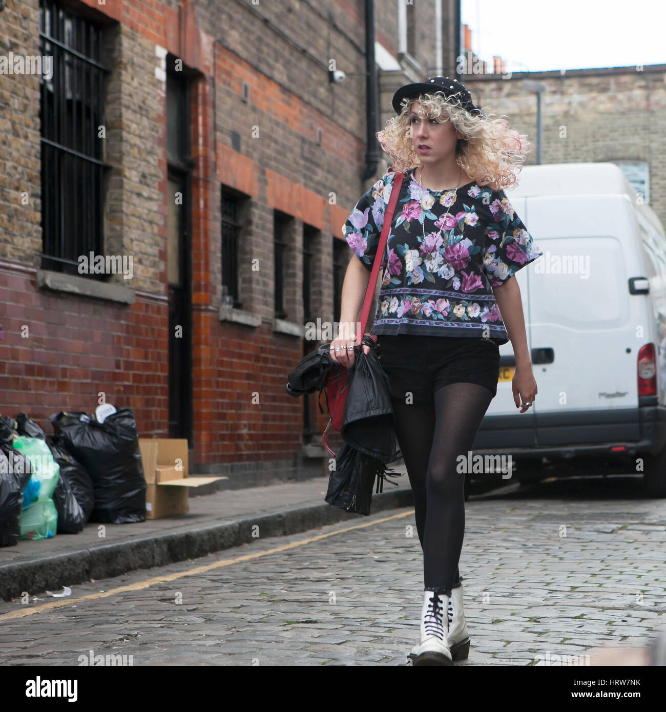 Londres, Inglaterra - Julio 12, 2016 moda mujer rubia en múltiples colores,  blusa pantys negro, cortos y un sombrero púrpura está en Columbia Road.  Street Fotografía de stock - Alamy