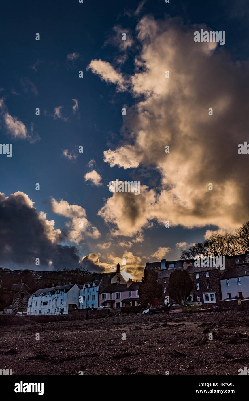 Atardecer reflejándose en las nubes encima de Portree, marzo de 2017, visto desde la orilla del Harbolur Portree, Isla de Skye, Escocia, Reino Unido Foto de stock