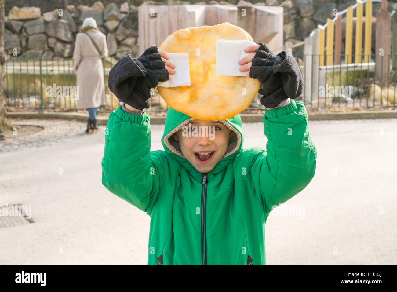 Los siete años de edad sosteniendo un Lángos, una húngara fritos flatbread. Viena, Austria, Europa. Foto de stock