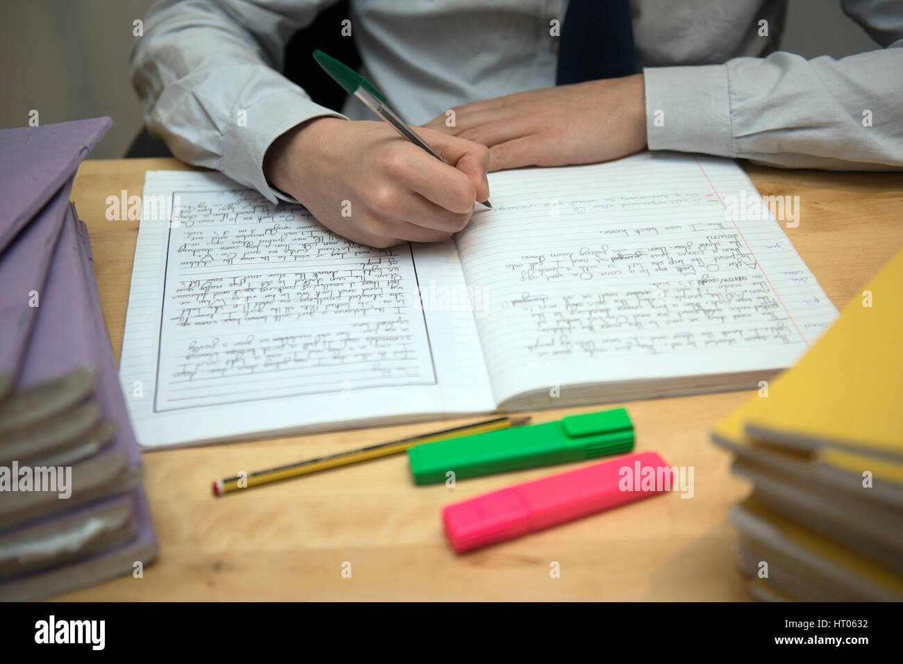 Una maestra de escuela primaria, marcando una deberes de inglés del alumno. Foto de stock