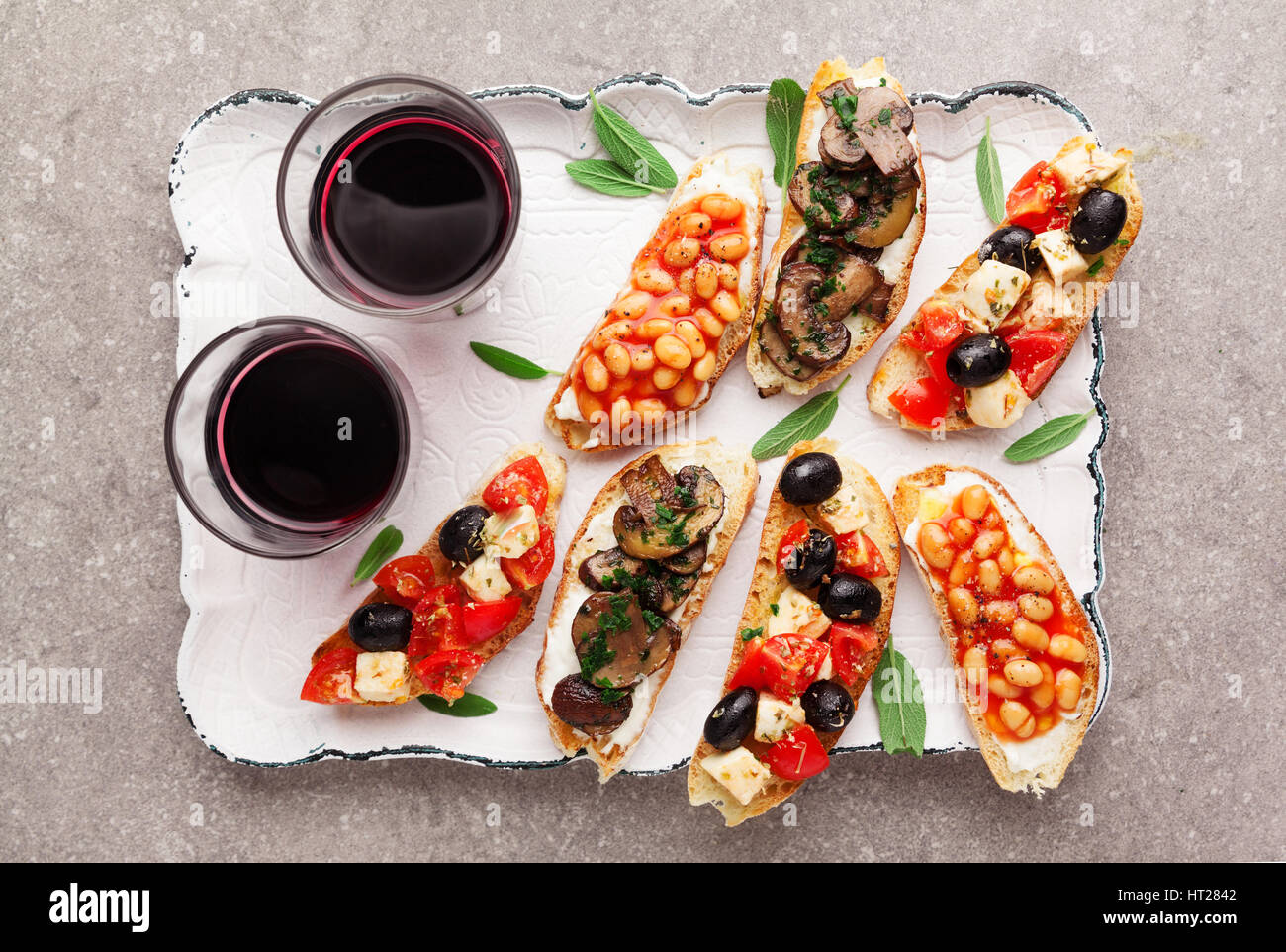 Brushetta set para el vino. Variedad de pequeños bocadillos con ensalada  Caprese , judías blancas a la parrilla con salsa de tomate y freír los  champiñones con suaves chee Fotografía de stock 