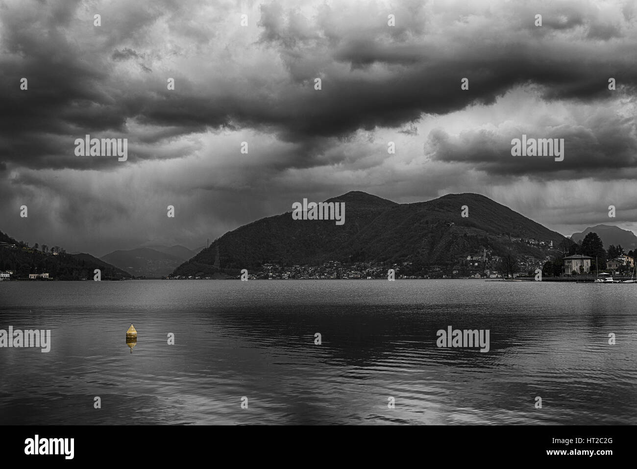Tarde nublada sobre el lago de Lugano con amarillo boya flotante, Porto Ceresio - Varese - Italia Foto de stock