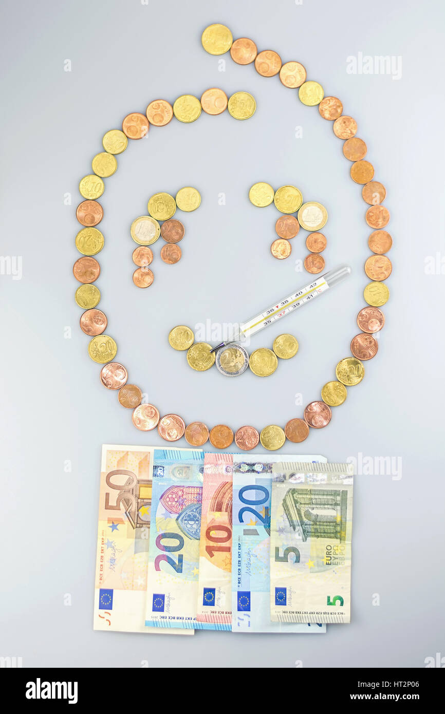 Triste smiley enfermos hechas de monedas de euro con una manta de billetes con un termómetro. Foto de stock