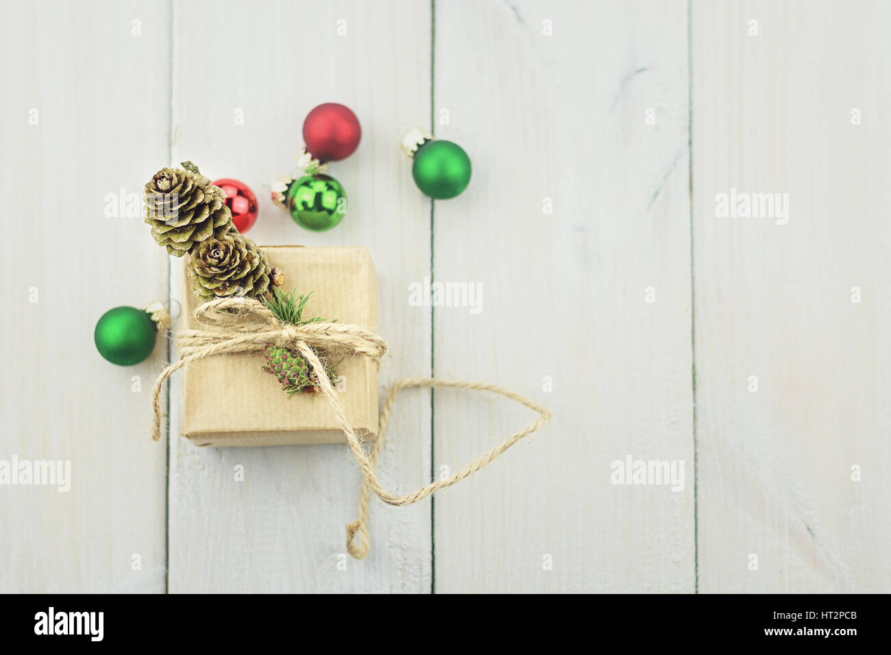Cuadro pequeño sobre un fondo de madera atados con una cuerda, decorada con una ramita de árboles de Navidad, bolas de Navidad. Foto de stock