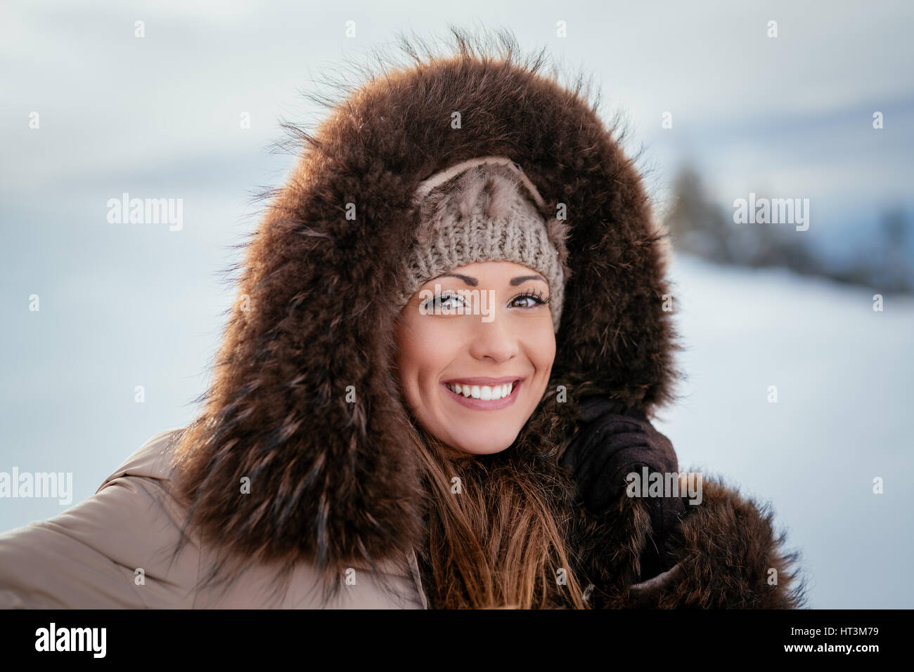Retrato de una hermosa niña sonriente al aire libre en invierno. Mirando a la cámara. Foto de stock