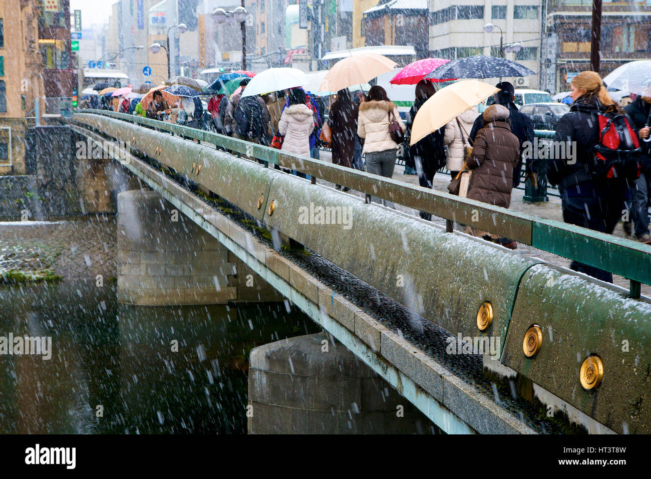 Los peatones en el puente durante la tormenta de nieve en el distrito Gion de Kyoto, Japón. Foto de stock