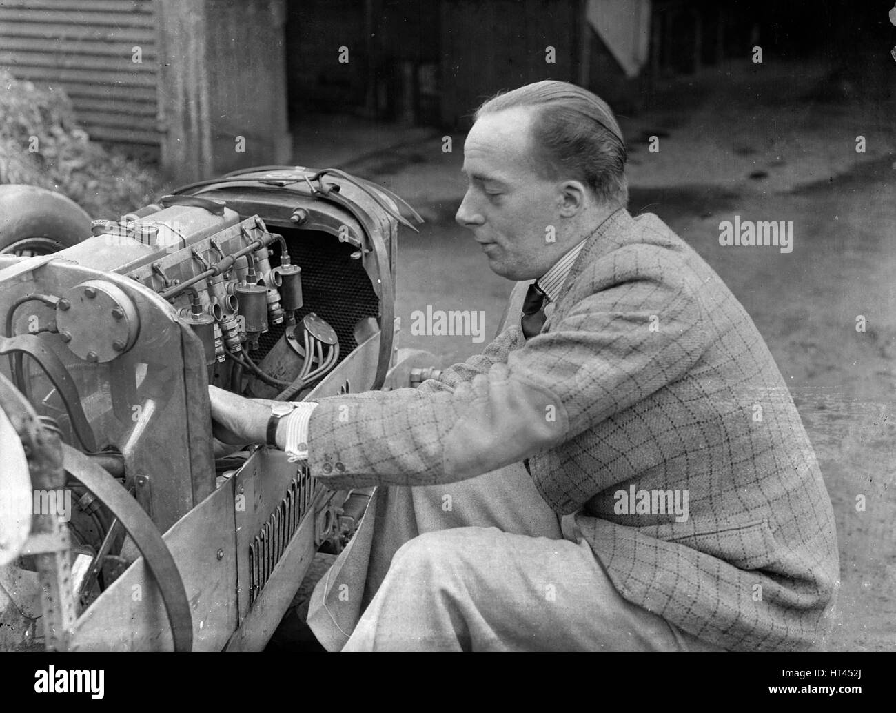 Charles Mortimer trabajando en el motor de un MG KN especial, c1930s Artista: Bill Brunell. Foto de stock