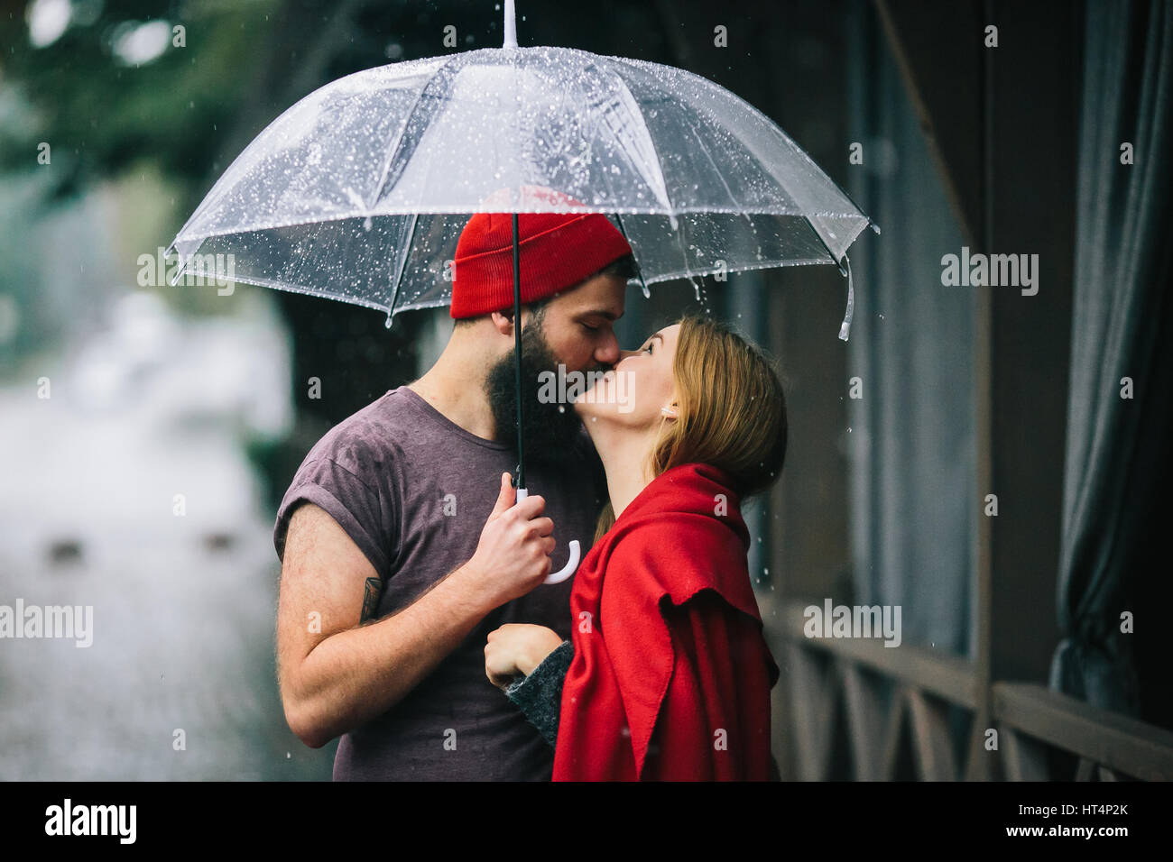 Chico y chica posando juntos en la lluvia en una calle de la ciudad  Fotografía de stock - Alamy