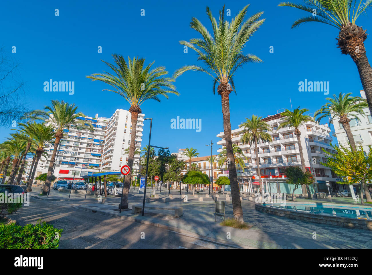 Sant Antoni de Portmany, Ibiza, noviembre 6th, 2013: Turismo en España. La gente espera en una parada de taxis. Palm parque peatonal arbolada y una fuente. Foto de stock