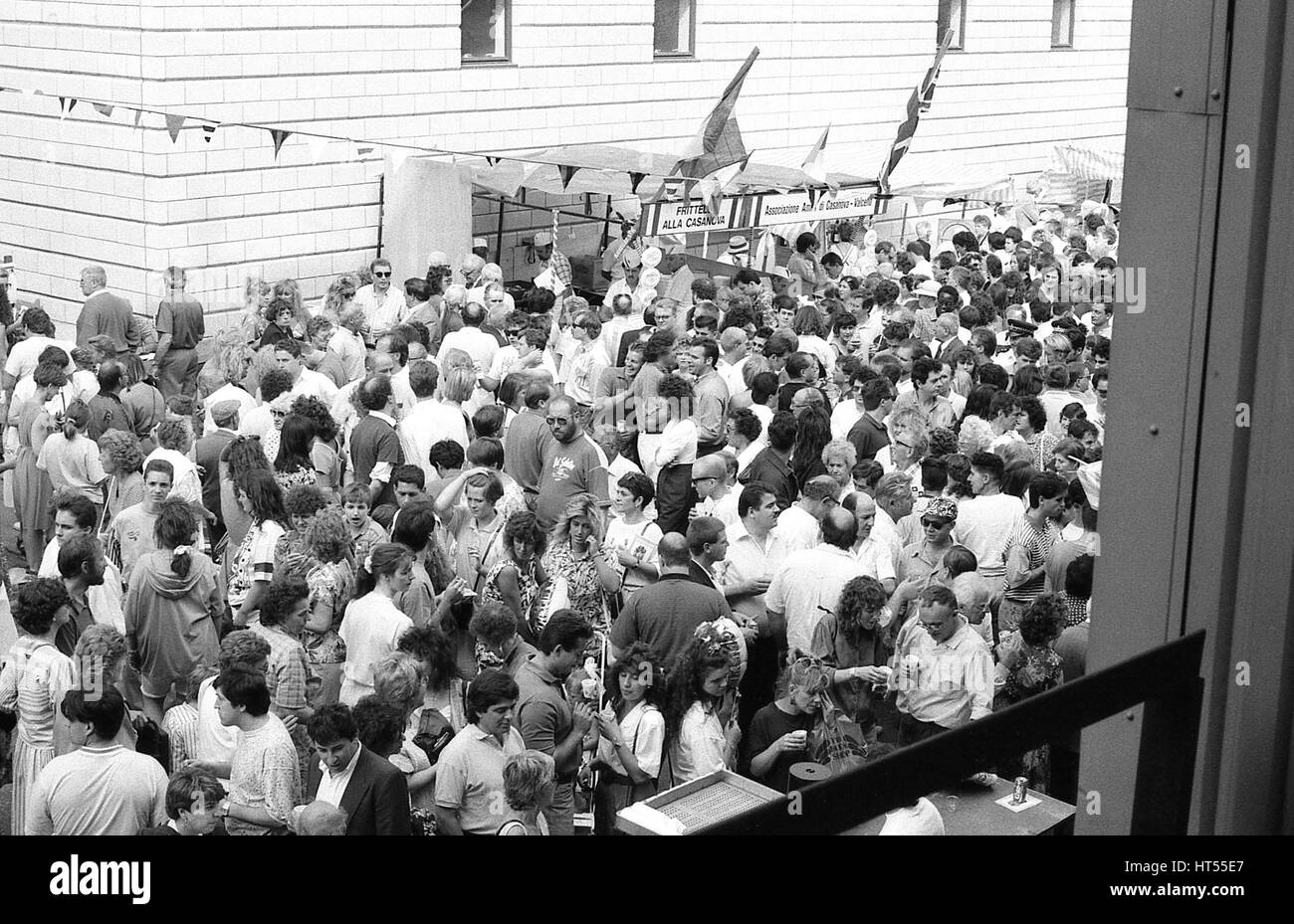 Multitudes de personas toman parte en la anual fiesta callejera italiana en el Warner Street en Clerkenwell, Londres el 21 de julio de 1990. La parte siguiente de la procesión religiosa de Santa María del Carmelo en lo que fue, tradicionalmente, el barrio italiano de Londres. Foto de stock