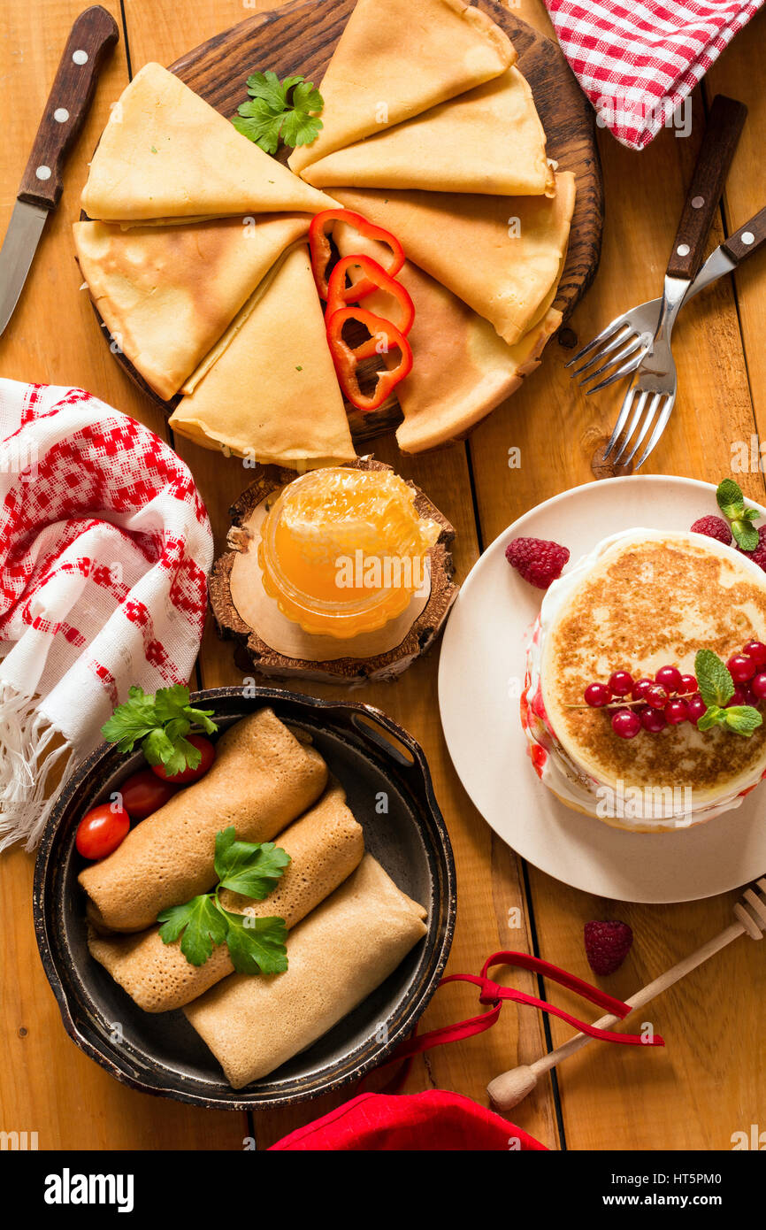 Diversos tipos de crepes y tortitas sobre mesa de madera rústica, vista superior Fotografía de