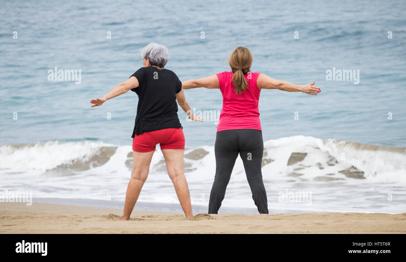 Estiramiento de las ancianas en la playa a mantenerse en forma diaria de clase en España Foto de stock