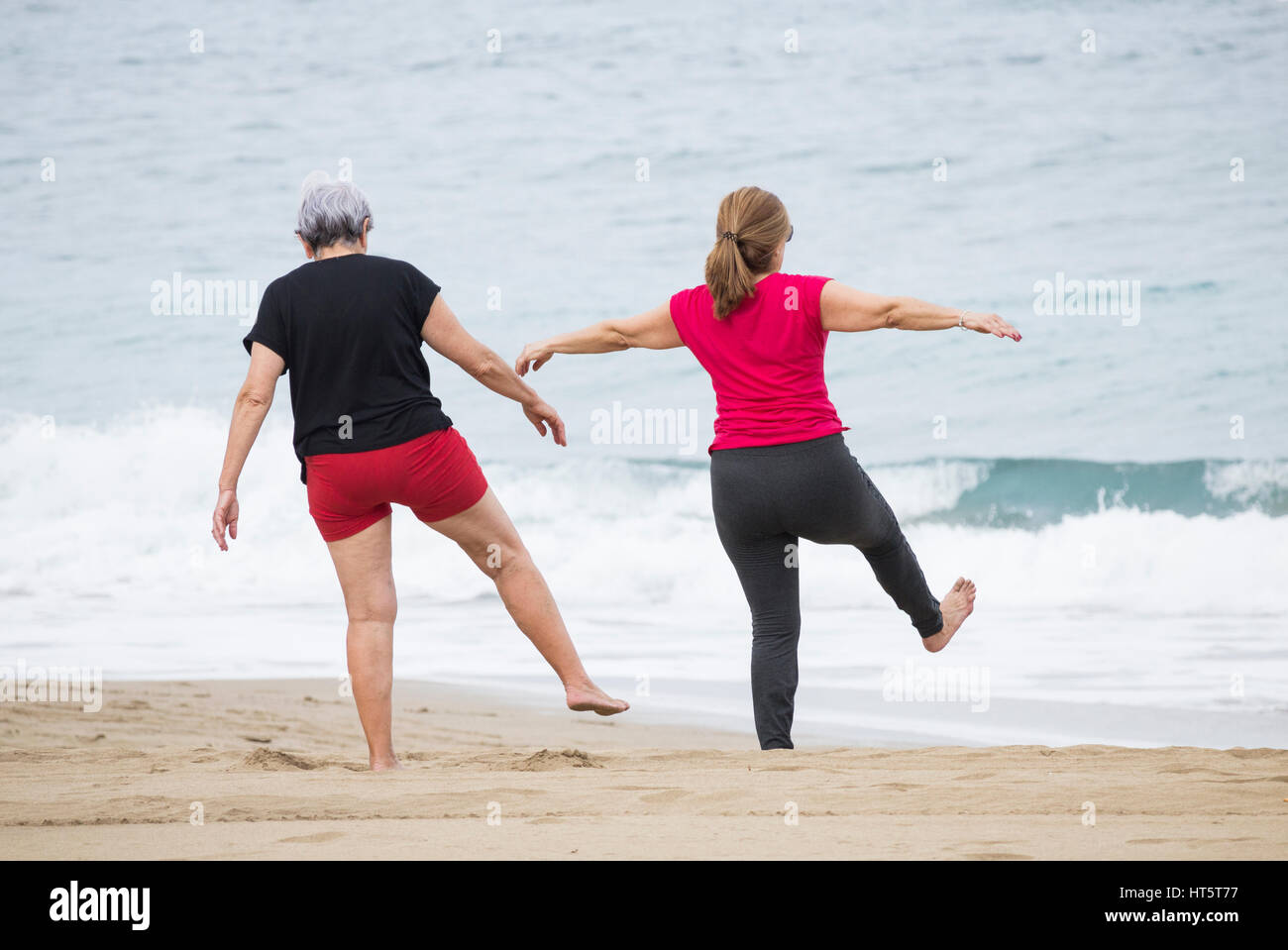 Estiramiento de las ancianas en la playa a mantenerse en forma diaria de clase en España Foto de stock