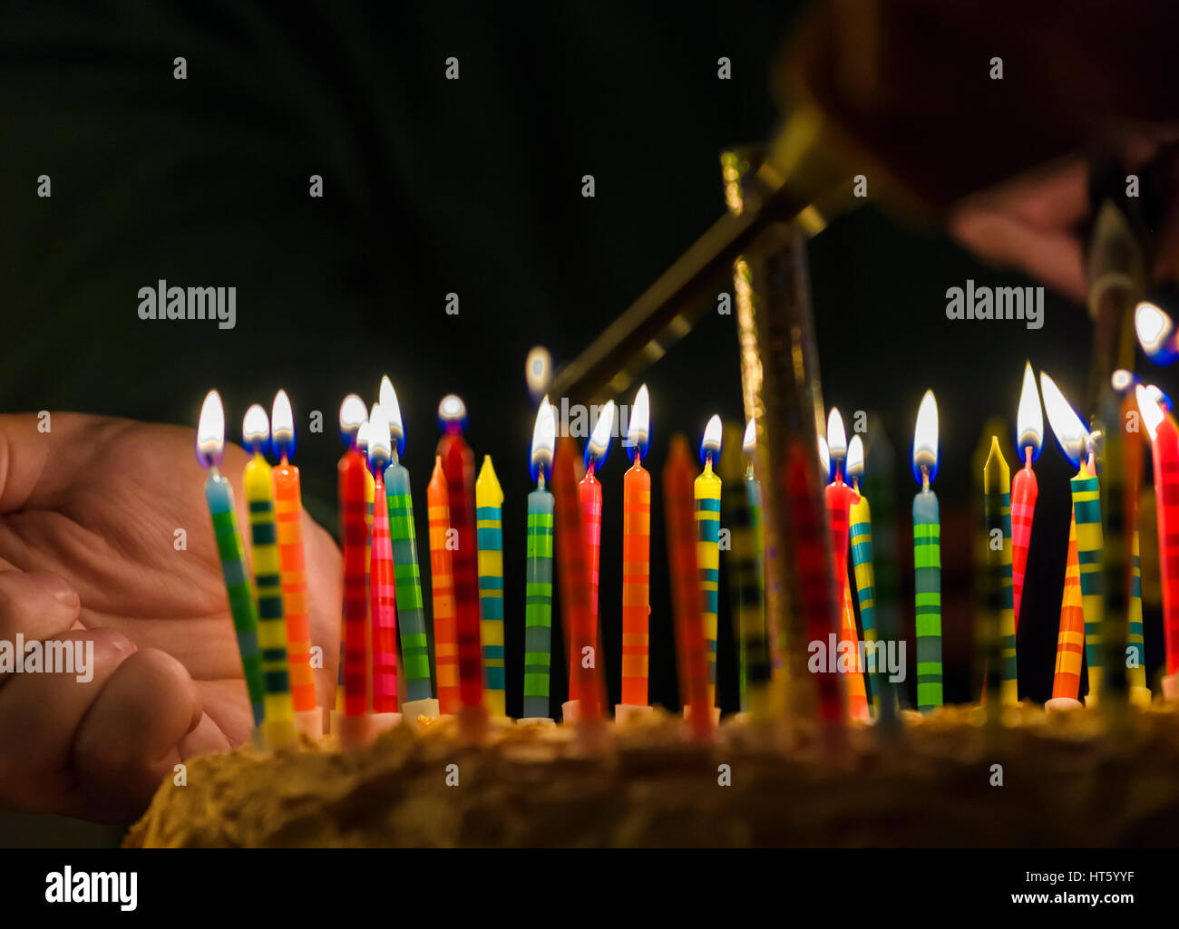 Pastel de cumpleaños con vela de número 18 en backgraund azul prendido  fuego por encendedor. de cerca