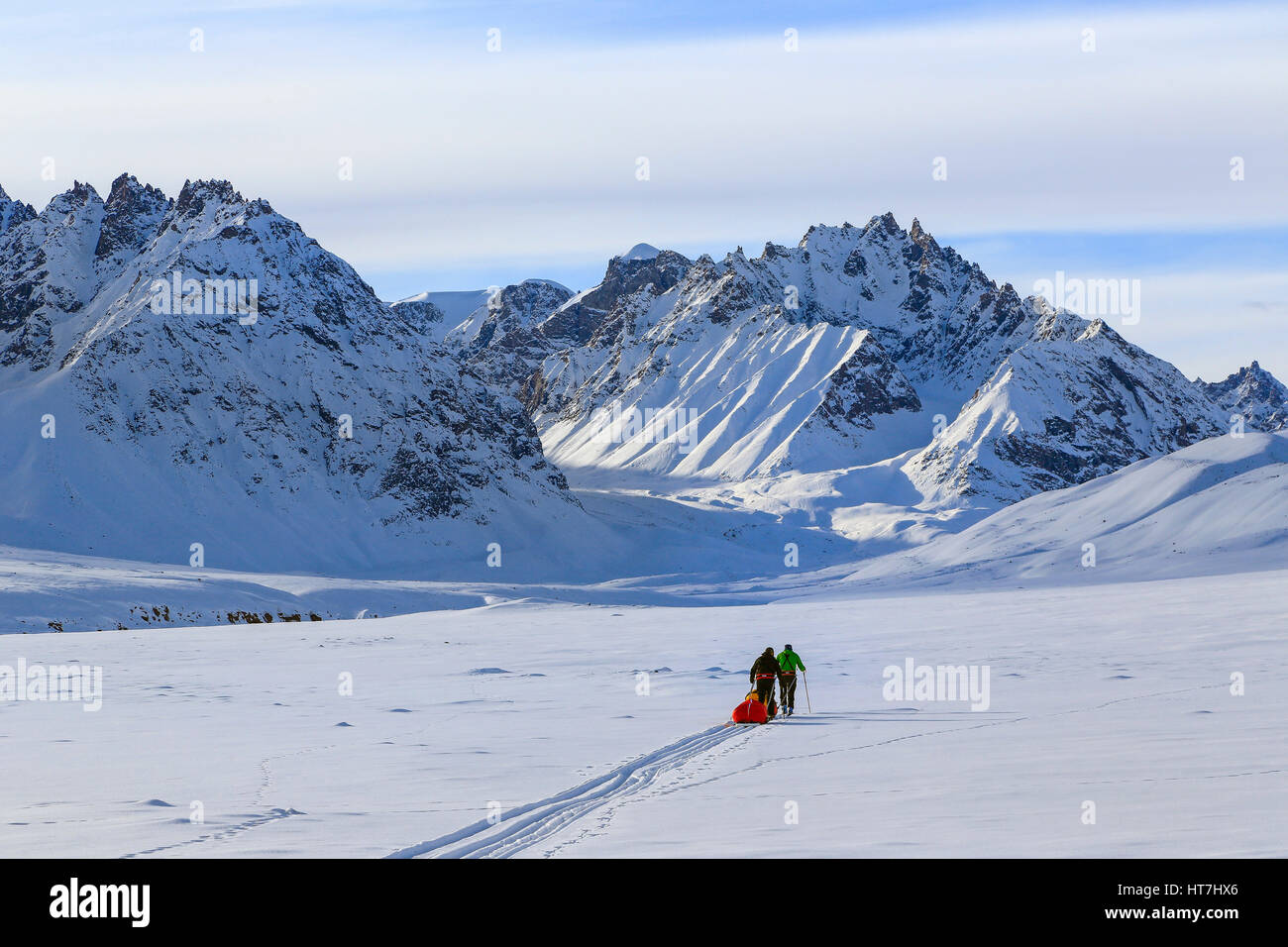 Equipo de alpinismo tirando Pulk trineos en el camino a los Alpes Stauning en Groenlandia Foto de stock