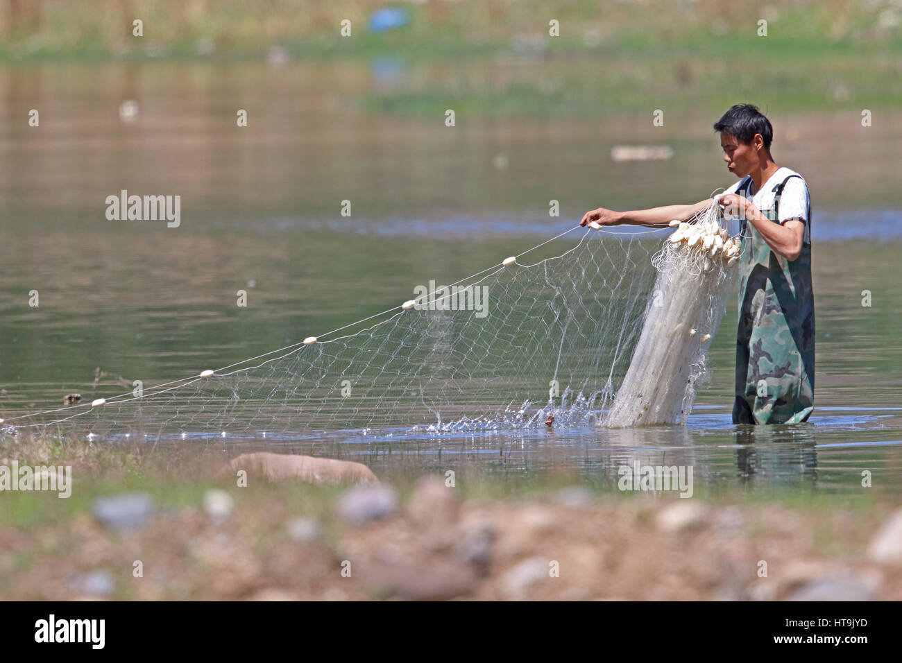 Ajuste de hombre net en río de montaña superficial Hebei, China puede Foto de stock