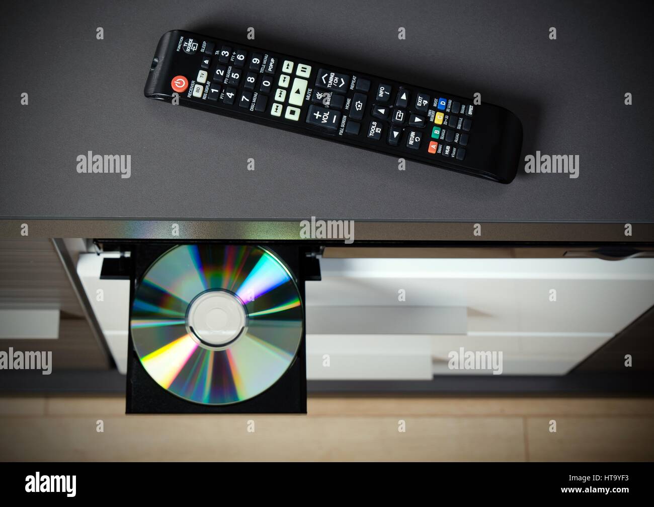 Control remoto y el reproductor de Blu-ray o reproductor de DVD con el disco insertado Fotografía de stock -