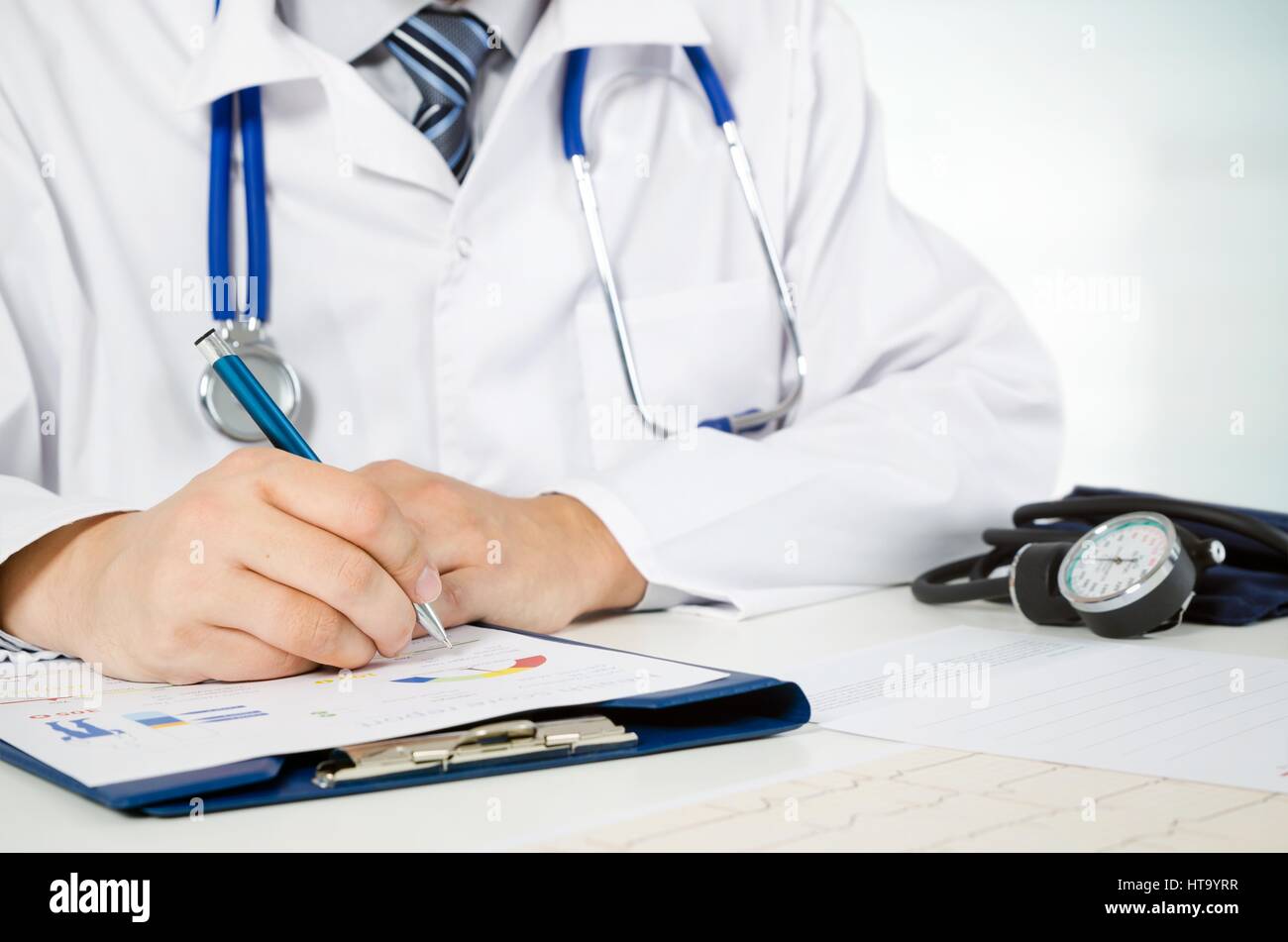 Médico que trabaja en su escritorio en el hospital. Concepto de médicos y de atención sanitaria. Foto de stock