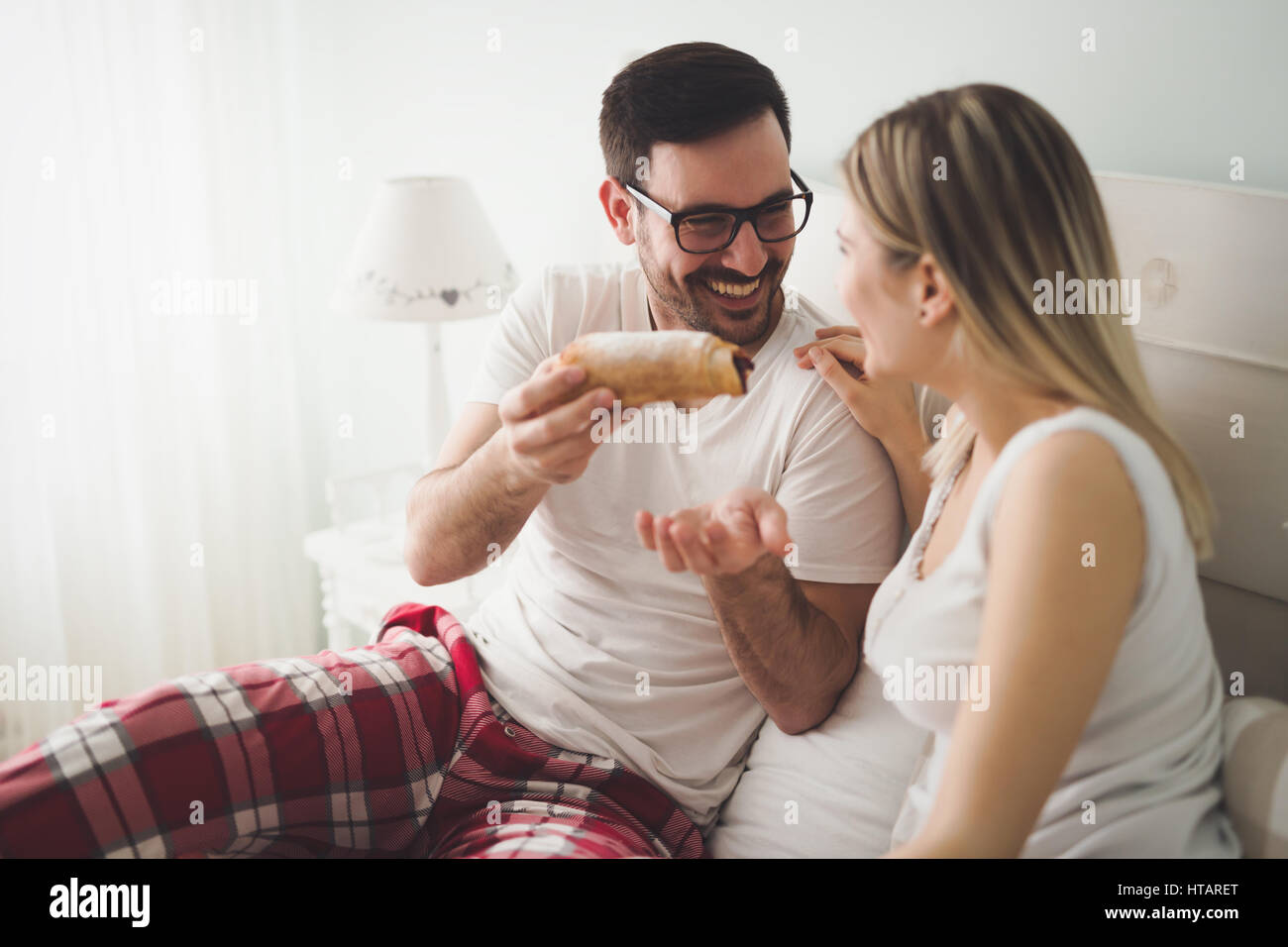 Pareja romántica come el desayuno en la cama Foto de stock