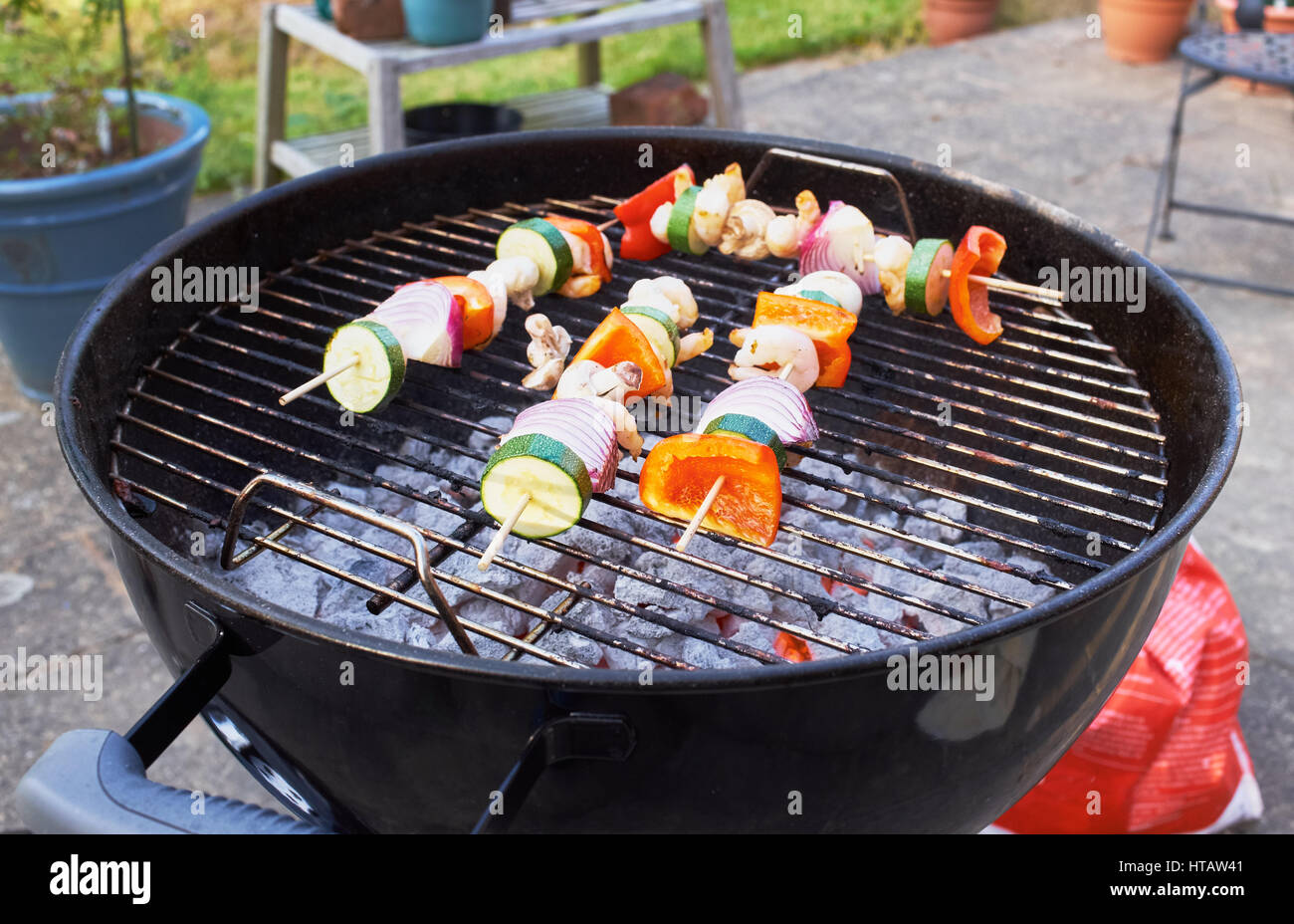Un kebab de gambas y verduras cocinar en una barbacoa de carbón. Foto de stock