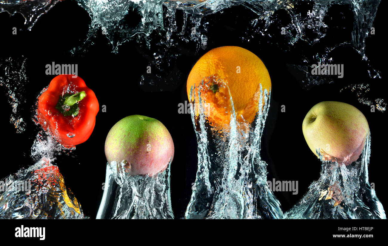 Con salpicaduras de agua disminuye con naranjas,el pimiento y las manzanas en el arte mezclado en studio velocidad técnica e iluminación. Foto de stock