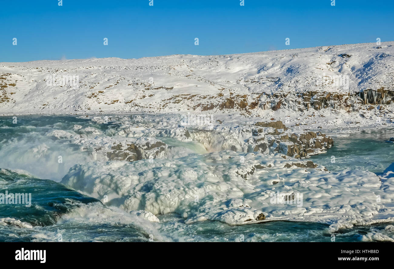 Una cascada congelada en Islandia con el cielo azul en un día de invierno Foto de stock