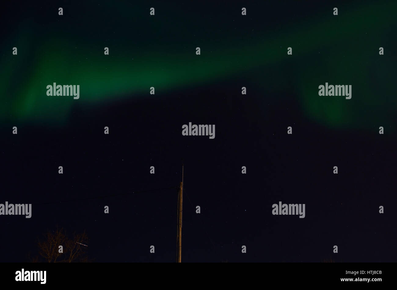 Majestuosa aurora boreal en el oscuro fondo del cielo nocturno lleno de estrellas Foto de stock