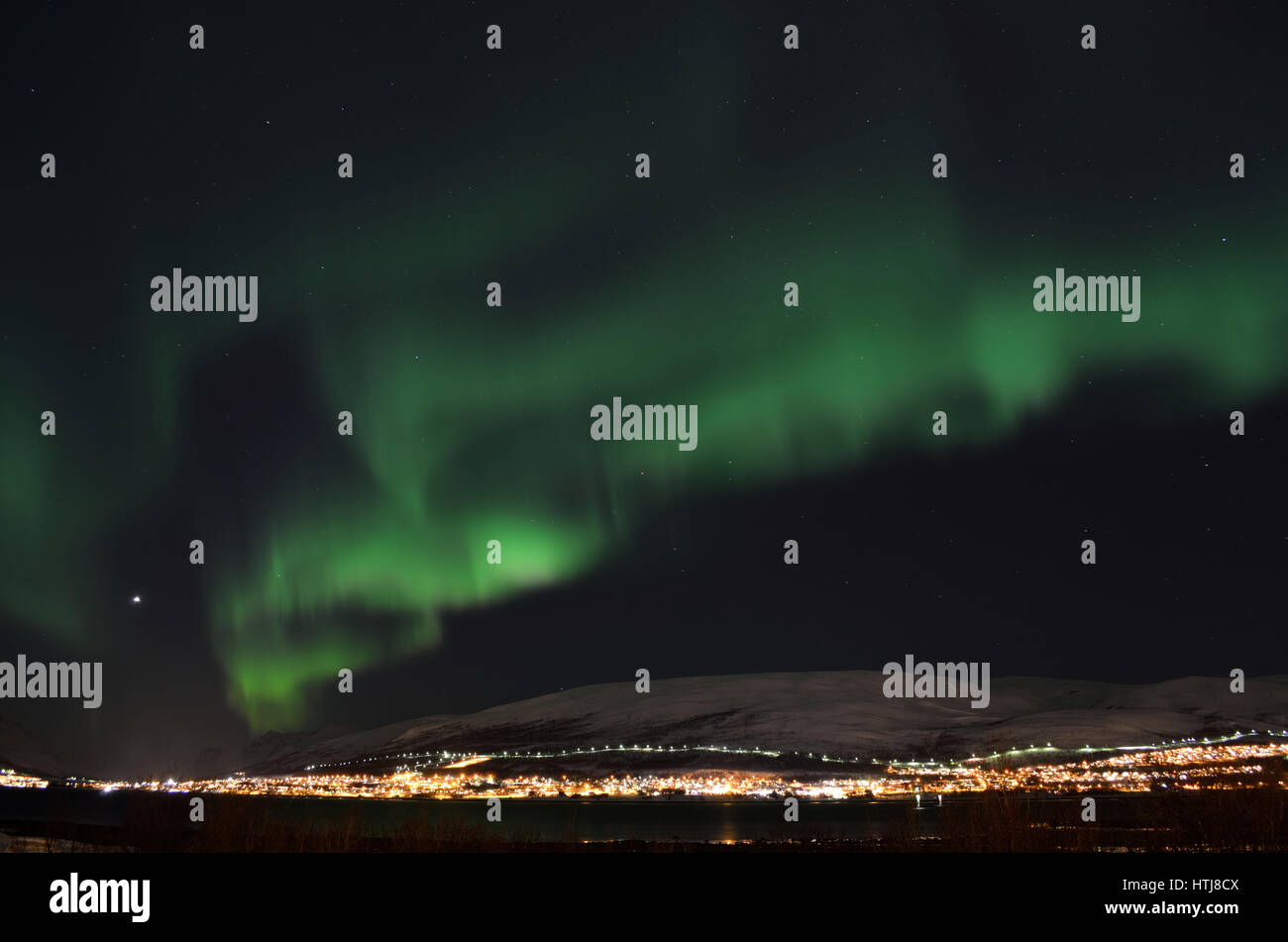 Mighty Northern light bailar sobre nevados picos de montaña en el norte de Noruega en el asentamiento de la isla Ballena Foto de stock