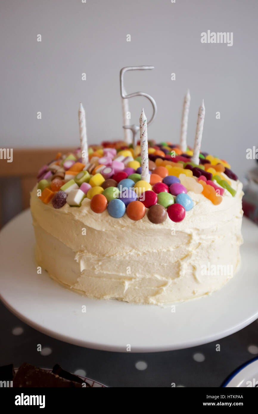 Pastel de cumpleaños de niños con cinco velas y el número cinco. Foto de stock