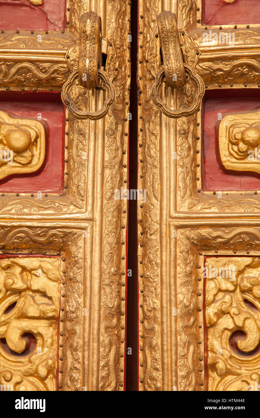 Pomo de la puerta y los diseños en relieve de las nubes y los dragones de la puerta de la Ciudad Prohibida, Beijing, China Foto de stock
