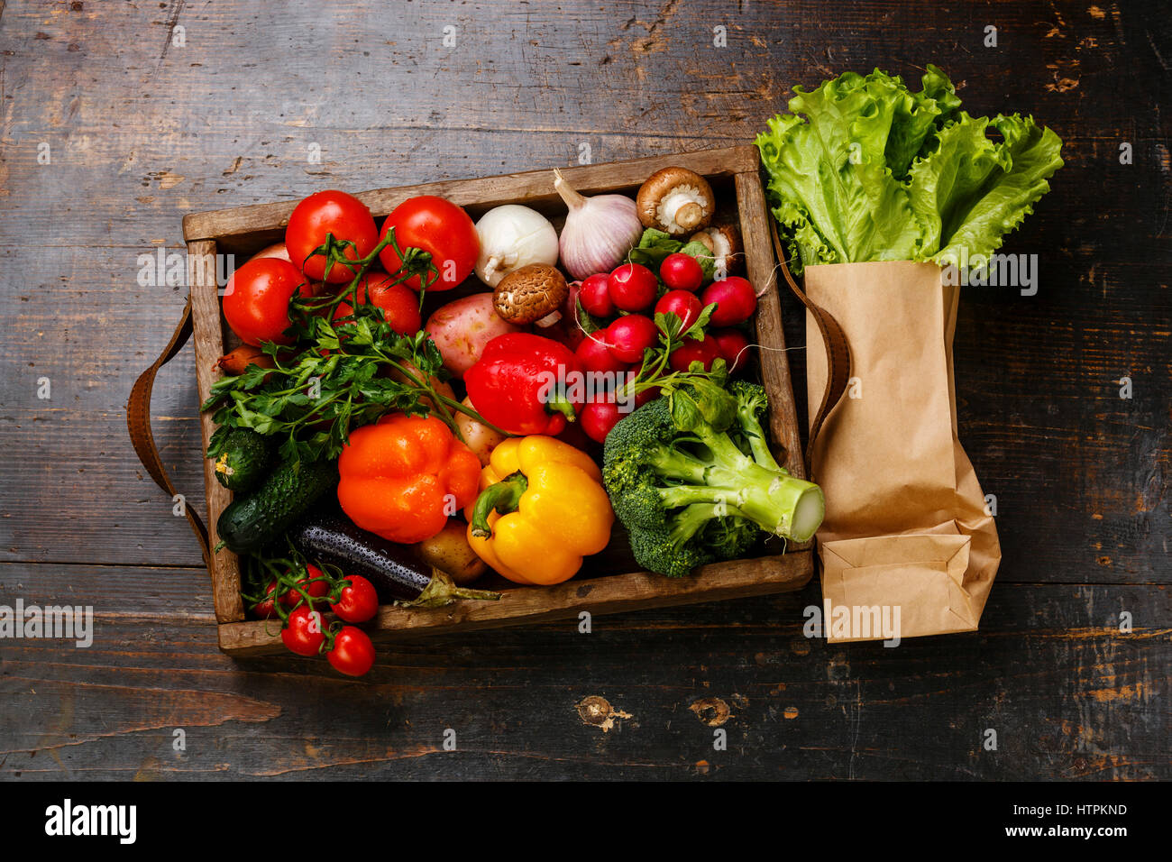 Las hortalizas frescas en caja de madera y lechuga sobre fondo de madera Foto de stock