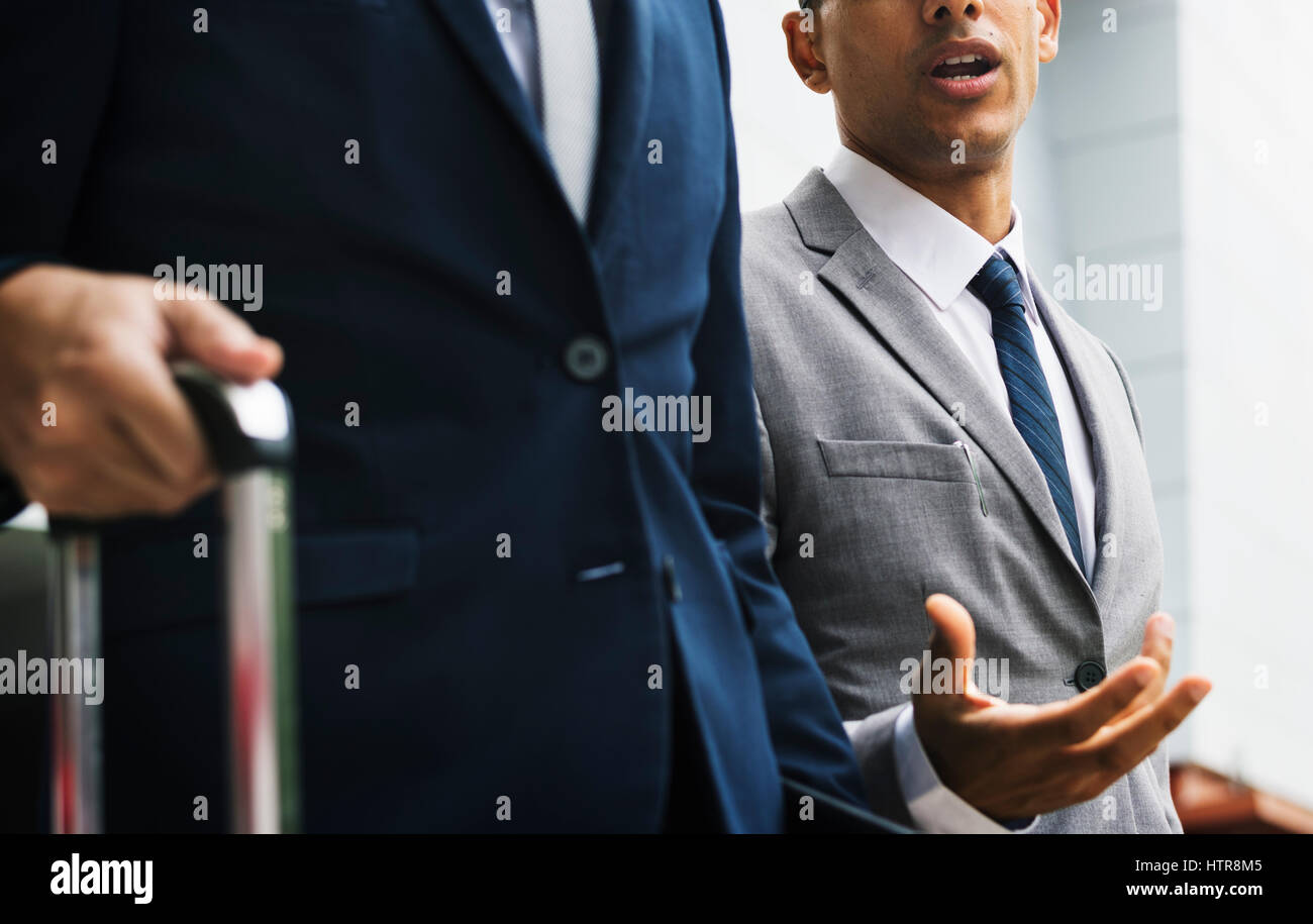 Los hombres de negocios caminar hablar equipaje Foto de stock