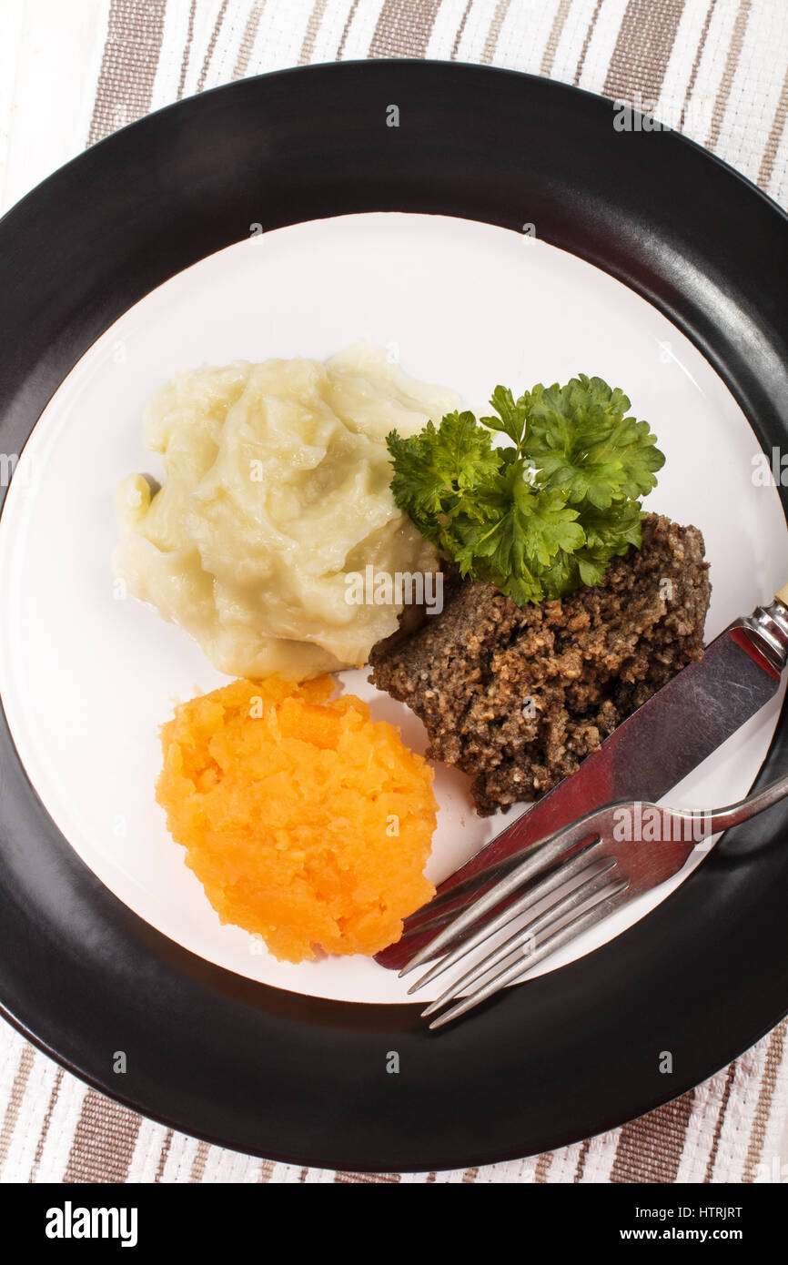 Plato típico escocés, haggis con puré de patatas, nabos y perejil en una placa Foto de stock