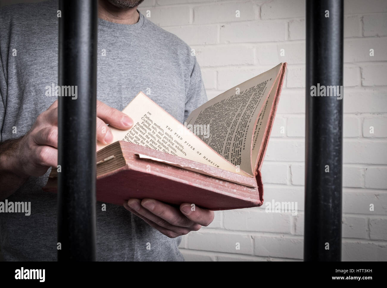 Lectura de un preso en su celda en la cárcel. Foto planteados por modelo para ilustrar la educación y la reforma en la cárcel Foto de stock