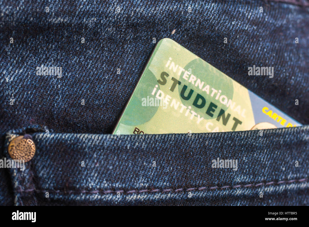 Carnet de estudiante internacional en el bolsillo trasero de los pantalones vaqueros azules Foto de stock
