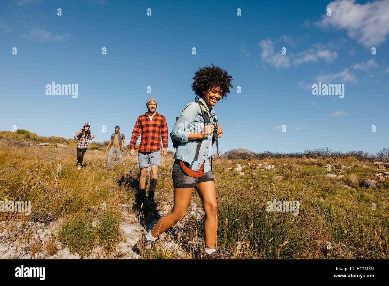 Grupo de jóvenes en una caminata por la campiña juntos. Jóvenes amigos, senderismo en la naturaleza. Foto de stock