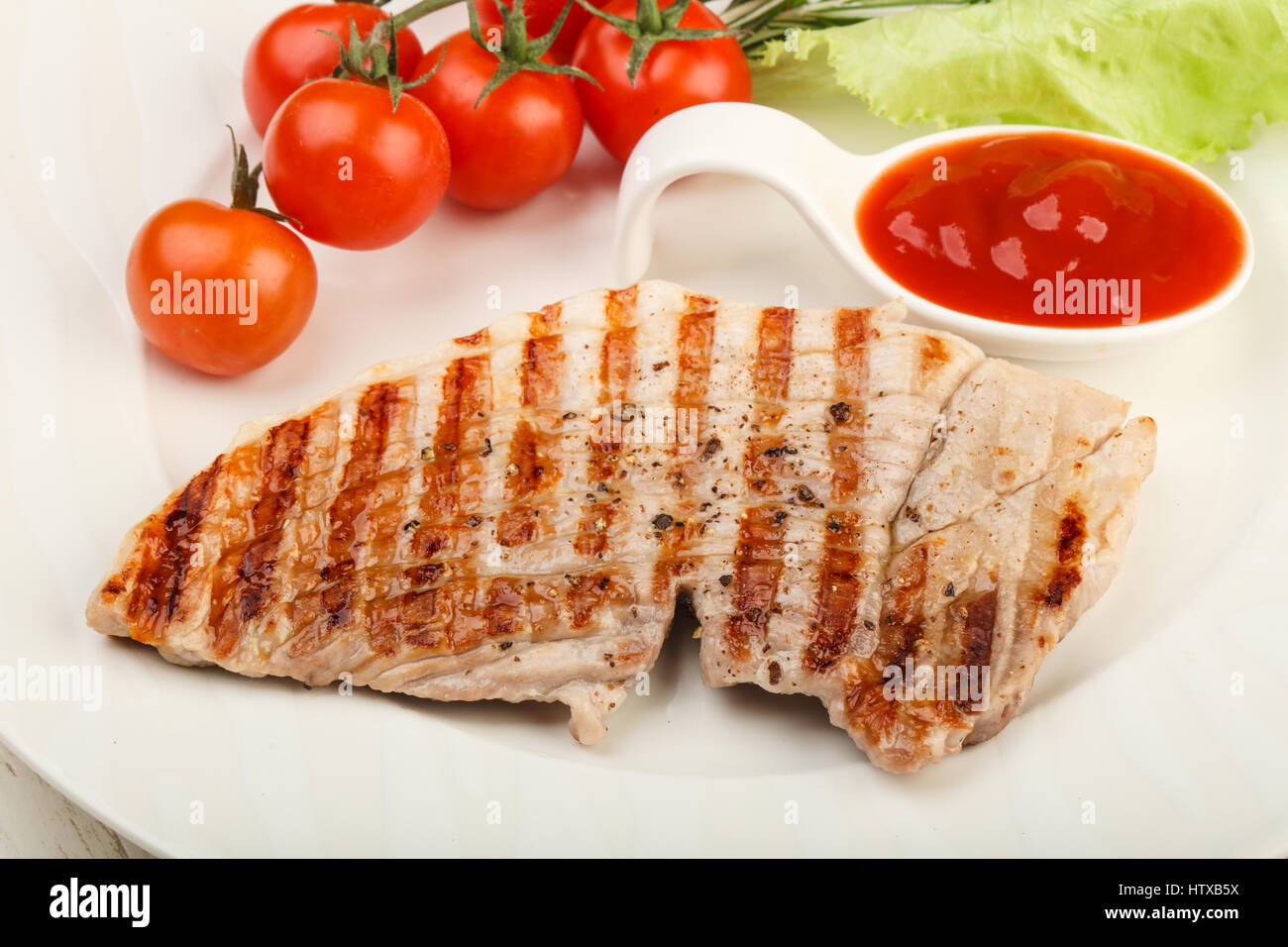 Puerto asado filete con la salsa de tomate ketchup y Romero Foto de stock
