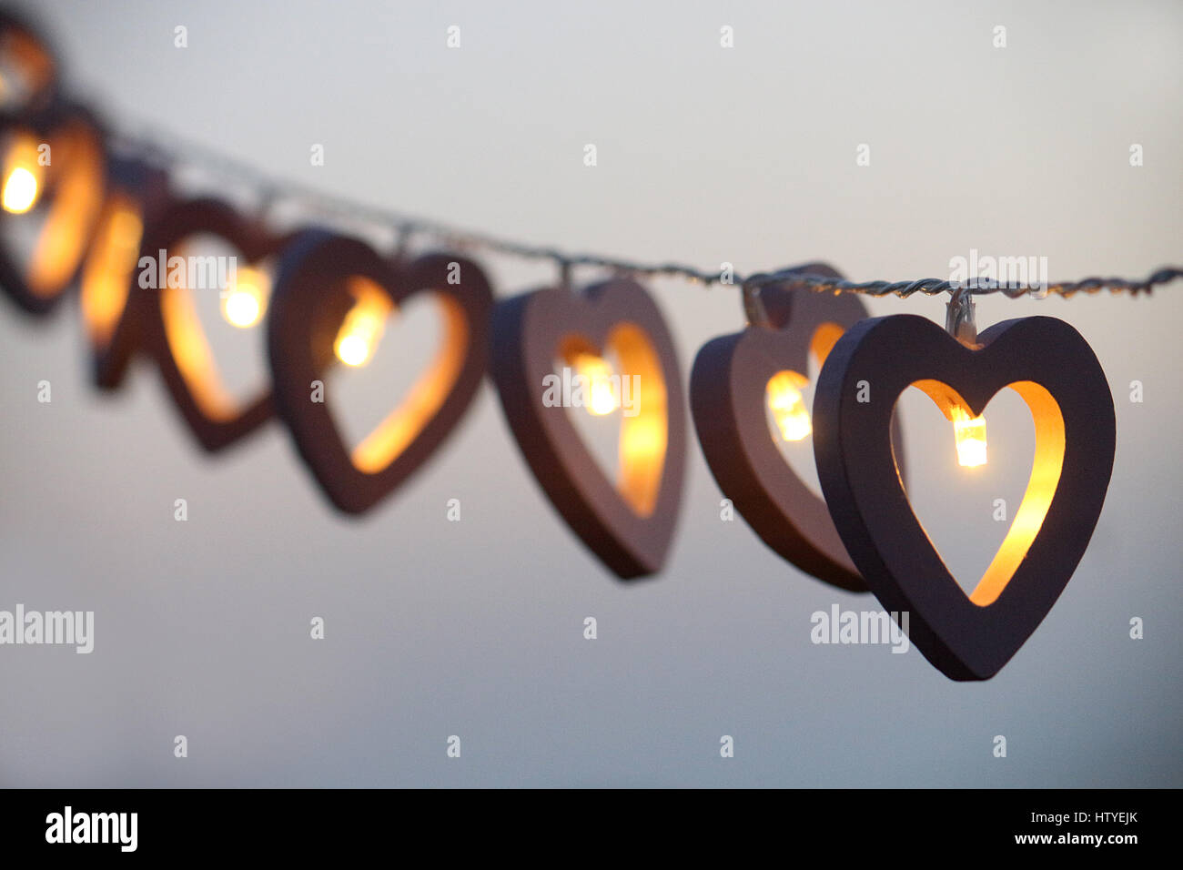 Luces de cadena en forma de corazón colgado en una fila Foto de stock