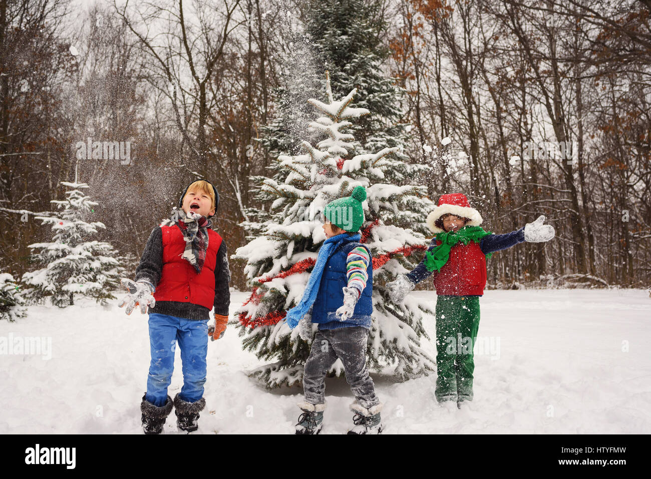 Tres niños jugando en la nieve. Foto de stock