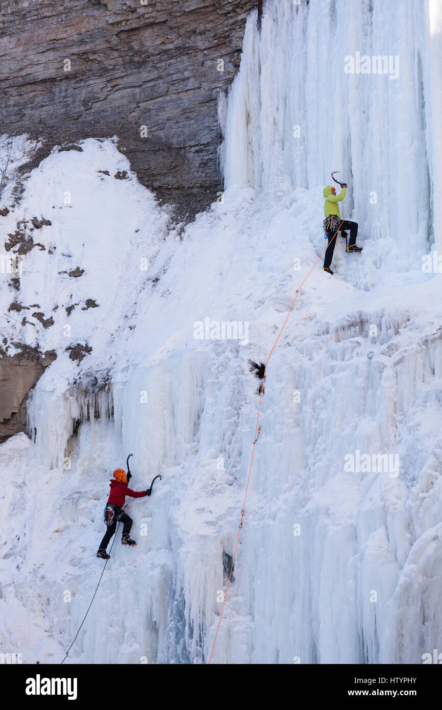 Los escaladores de hielo congelado subiendo El Buttermilk Falls en Hamilton, Ontario, Canadá. Foto de stock